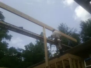 Carpenter setting a ridge beam over a new addition frame — Ice Dam Removal by Roofing Brothers in New Braunfels