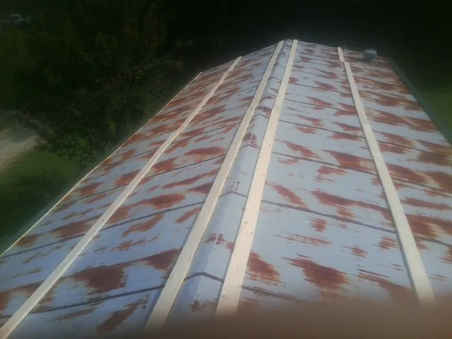 Rusted metal roof panels with new wood purlins before replacement — Storm Damage Roof Repair in New Braunfels by Roofing Brothers