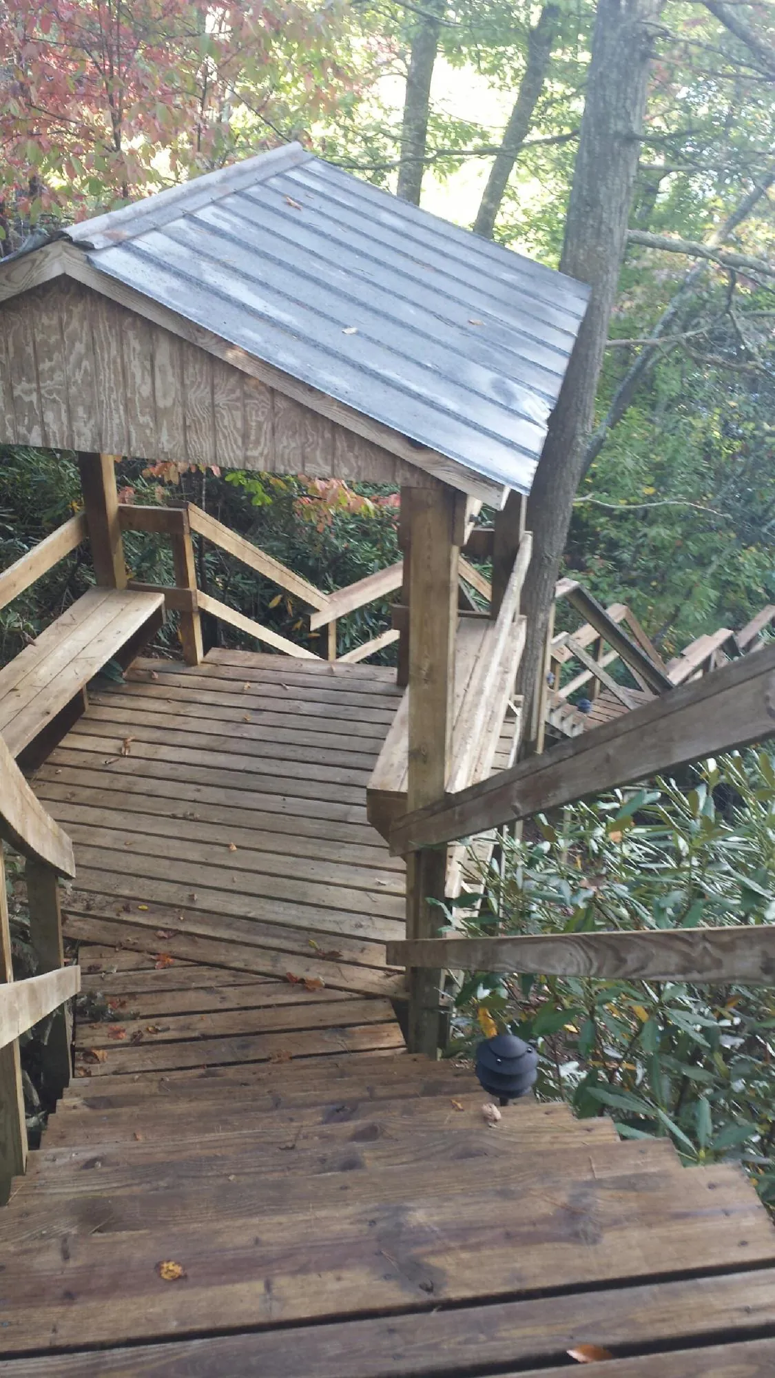 Metal roofed shelter over wooden steps on a wooded walkway — Skylight Repair & Installation work by our crew in New Braunfels