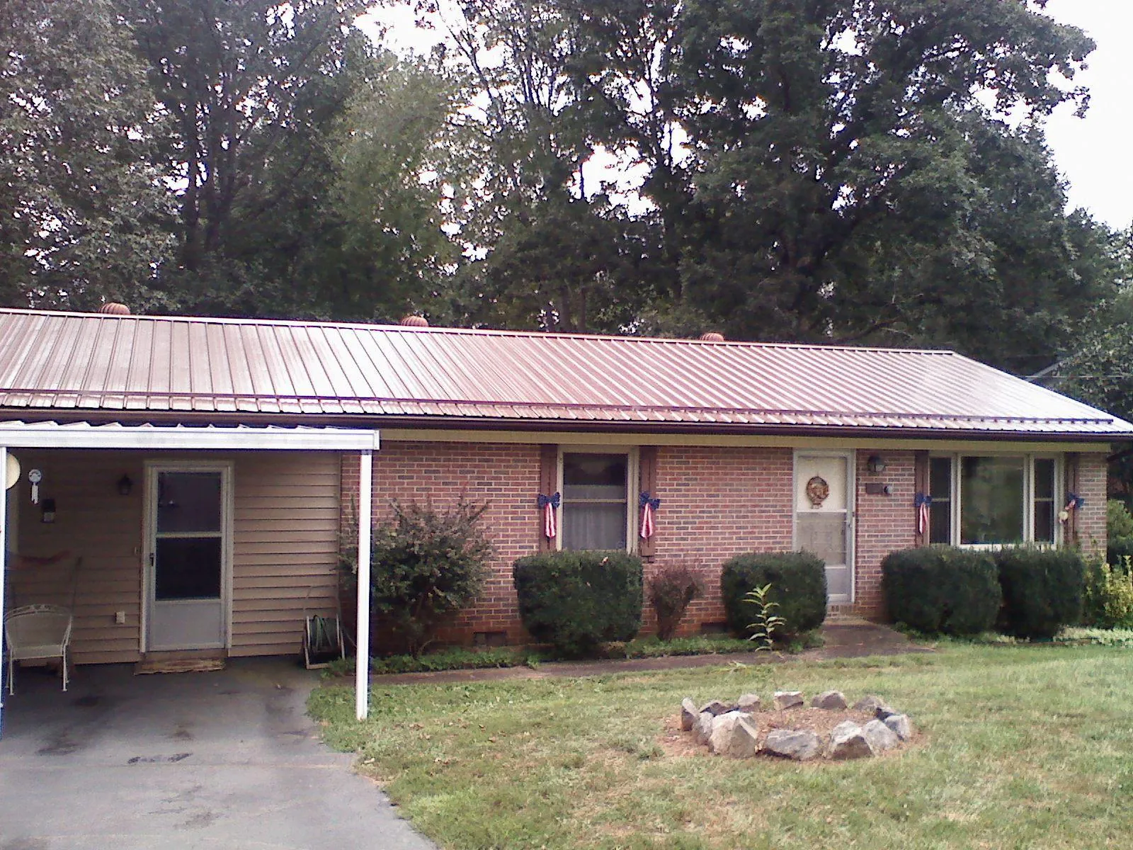 Bronze metal roof and carport on a brick ranch home — Roof Repair work by our crew in New Braunfels