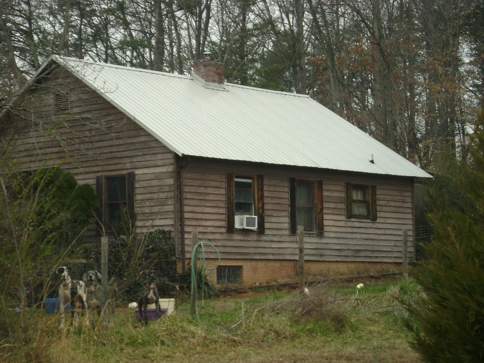 White metal roof on an old wood sided farmhouse, from a Metal Roof Installation job in New Braunfels